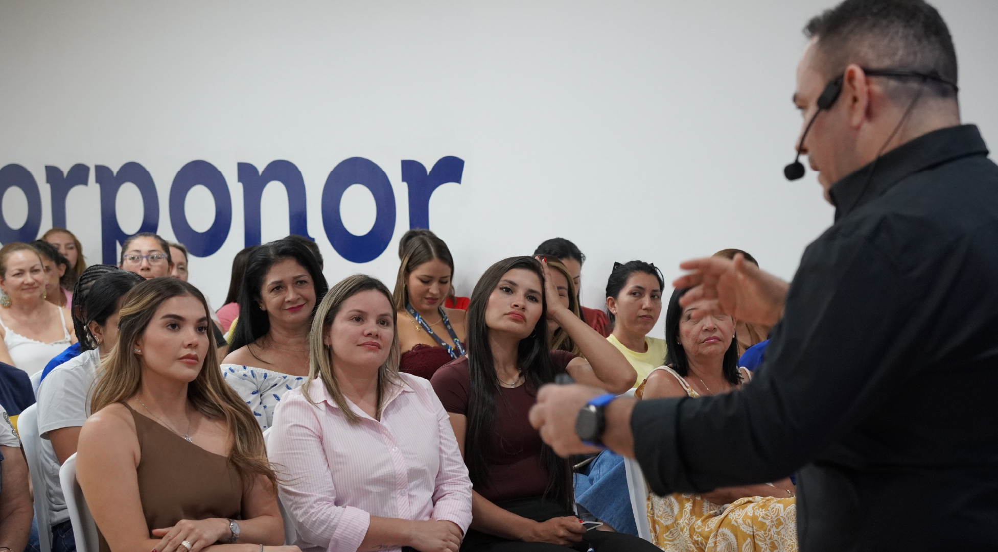 José Luis Ramírez con micrófono diadema frente a una audiencia femenina